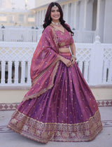 Woman in a traditional purple and gold outfit standing on a balcony.