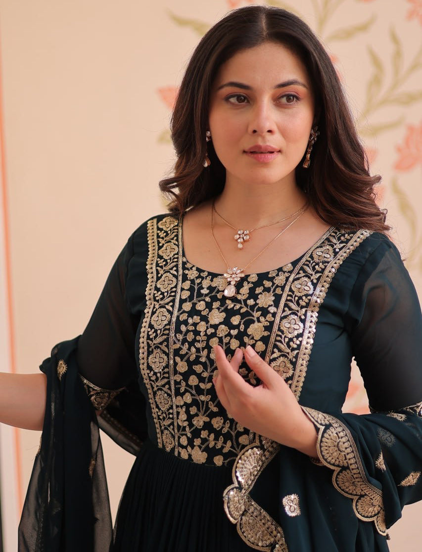 Woman wearing a black and gold embroidered traditional outfit against a floral background