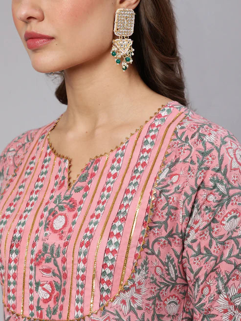 Close-up of a person wearing a pink floral patterned top with intricate detailing.