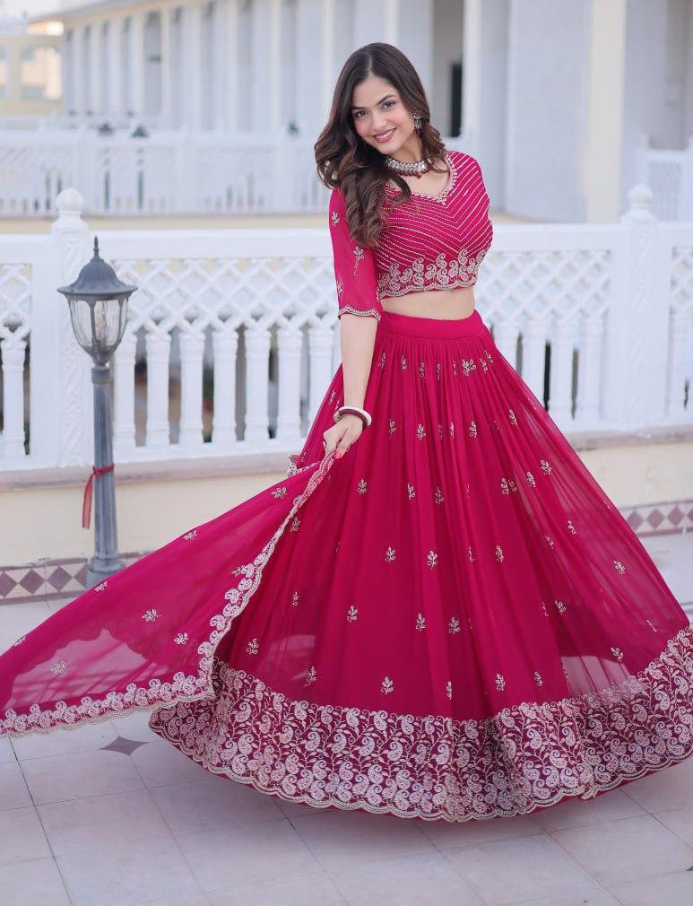 Woman in a red traditional outfit with white embroidery standing on a white porch.