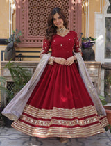 Woman wearing a red and gold traditional outfit with a decorative background