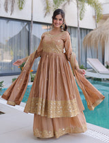 Woman in a peach and gold traditional outfit by a pool