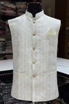 White embroidered vest on a mannequin with a blurred fabric background