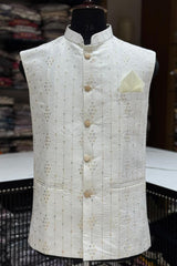 White embroidered vest on a mannequin with a blurred fabric background