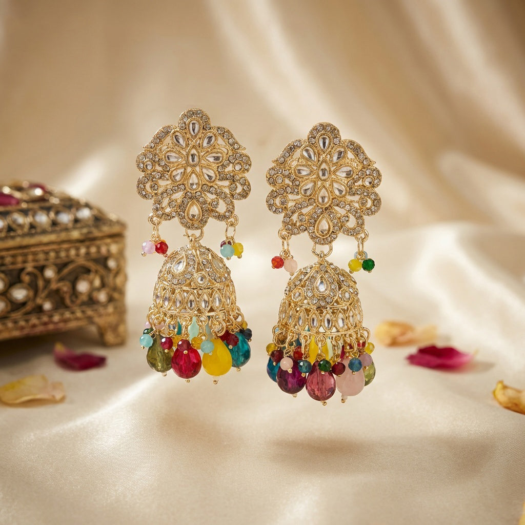 Ornate gold earrings with colorful beads on a soft beige background