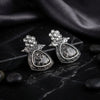 Pair of silver earrings on a dark marble surface