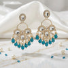 Gold and blue earrings on a marble surface with pearls.