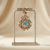 Decorative hanging ornament with colorful design on a stand against a beige background