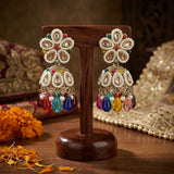 Colorful beaded earrings on a wooden stand with a decorative background