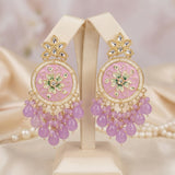 Ornate earrings with pink stones and gold accents on a stand.