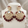 Ornate earrings with red gemstones on a mannequin bust.