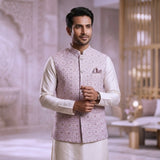 Man wearing a traditional outfit with a patterned vest in an indoor setting