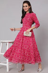 Woman wearing a pink patterned dress with a white background