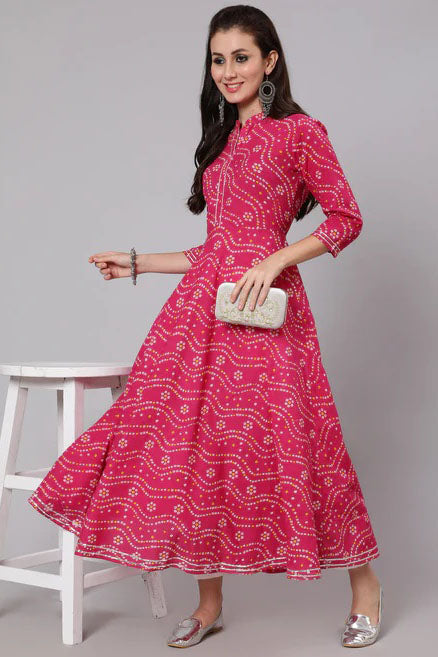 Woman wearing a pink patterned dress with a white background