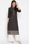 Woman wearing a black patterned kurta with white pants on a white background